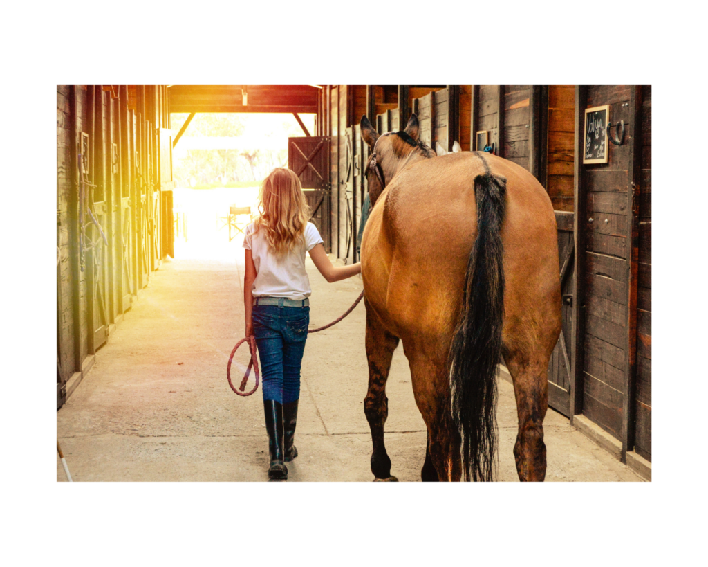 Equestrian leading her horse out of the barn. Equine assisted therapy can help as a form of anxiety treatment in Powhatan, VA here.