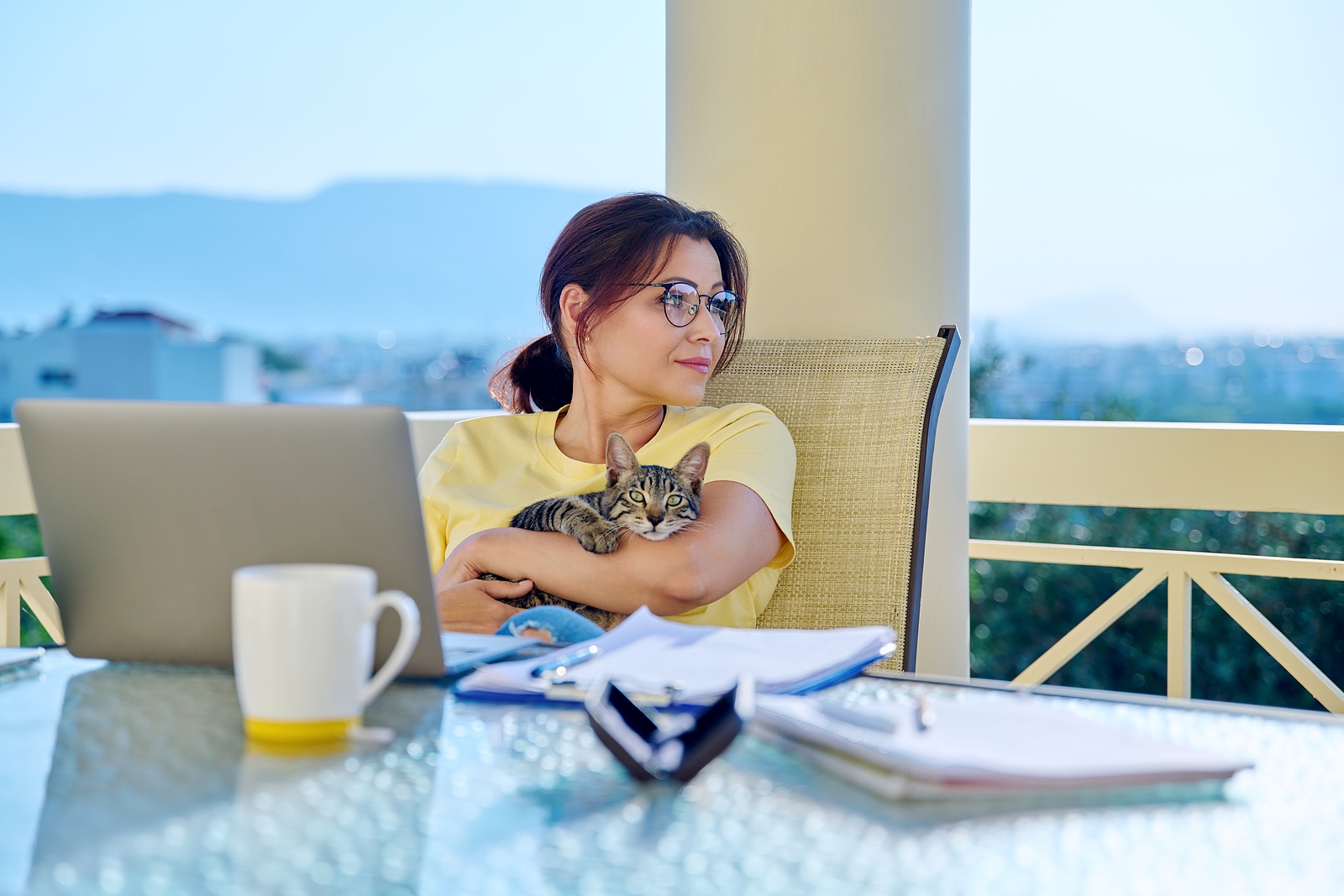 Image of a woman on the computer with her cat in her lap. This image could depict someone who is needing therapy for life transitions in Virginia. Get started today working through transitions with acceptance and commitment therapy with a life transition therapist in Virginia. 23103 | 23005 | 23113