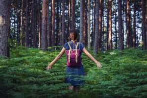 Woman standing in the forest deep breathing in a state of calm and peace. You too can obtain a state of peace with anxiety therapy in Virginia.