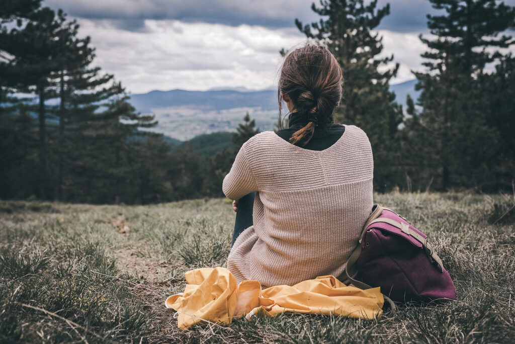 Woman taking a break from her hike to contemplate her existence. Is this post-pandemic world throwing you for a loop that you can't get out of? Therapy for depression and anxiety in Virginia can help break the cycle and get you on the path to happiness.