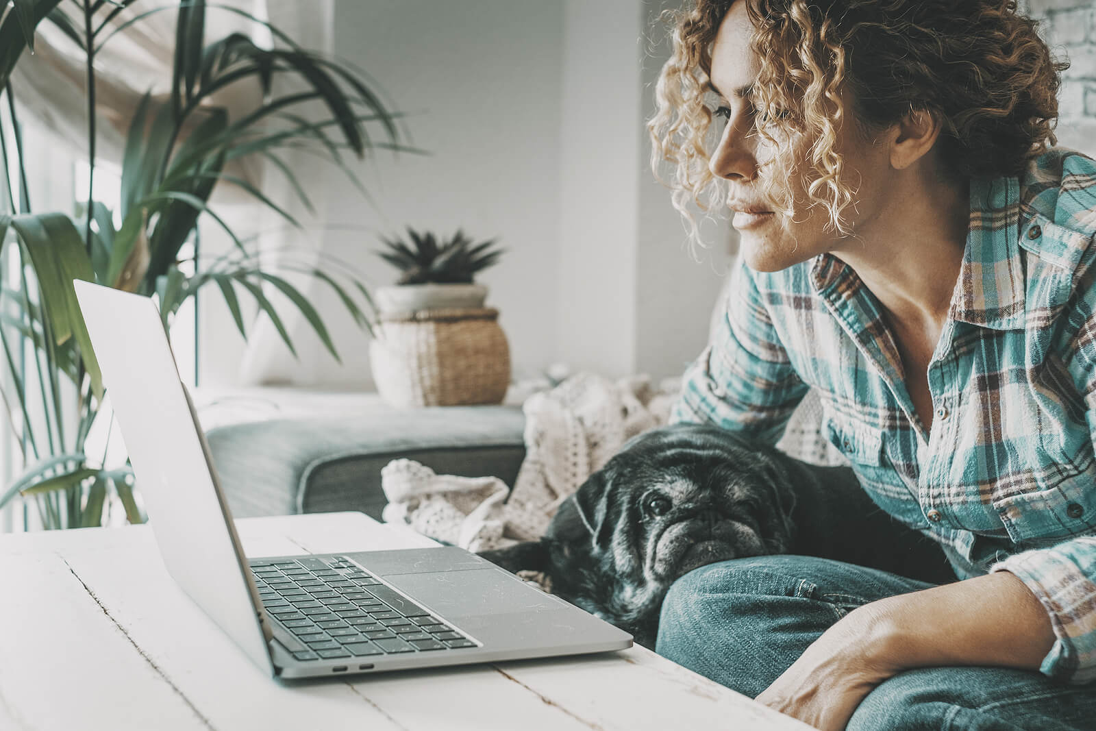 Woman sitting at her computer with her dog on her lap representing someone participating in online EMDR Intensives. Work with an online therapist in Virginia to process past trauma and move forward in your life. Learn more here.