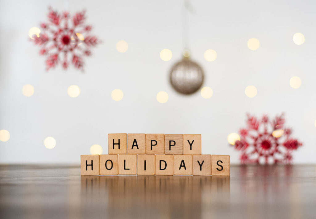 Wooden blocks rest on a table with letters that spell "happy holidays" with festive decor. Learn more about how an anxiety therapist in Richmond, VA can offer support with difficult holidays. Search for therapy for anxiety and other services by contacting an equine therapist in Virginia today. 