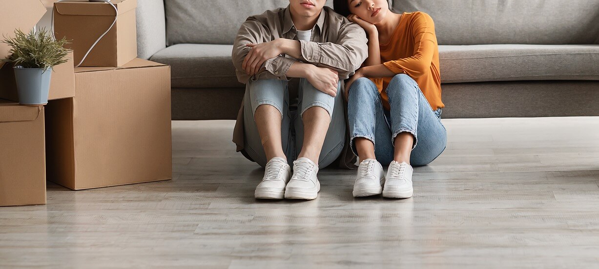 A couple sit on the ground next to moving boxes. This could represent the struggles of life transitions an anxiety therapist in Richmond, VA can address. Learn more about therapy for life transitions in Virginia and other services like equine therapy in Virginia.