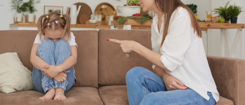 A child sits huddled up as their mother scolds her and points a finger. This could represent past memories that an anixety therapist in Richmond, VA can help you address. Learn more about therapy for trauma in Richmond, VA and other services today. 