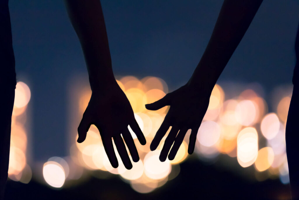 A close up of a couple about to hold hands. Learn more about the help a life transitions therapist in Fredericksburg, VA can offer with your relationship by searching for online therapy in Virginia. Search for therapy for life transitions in Virginia today. 