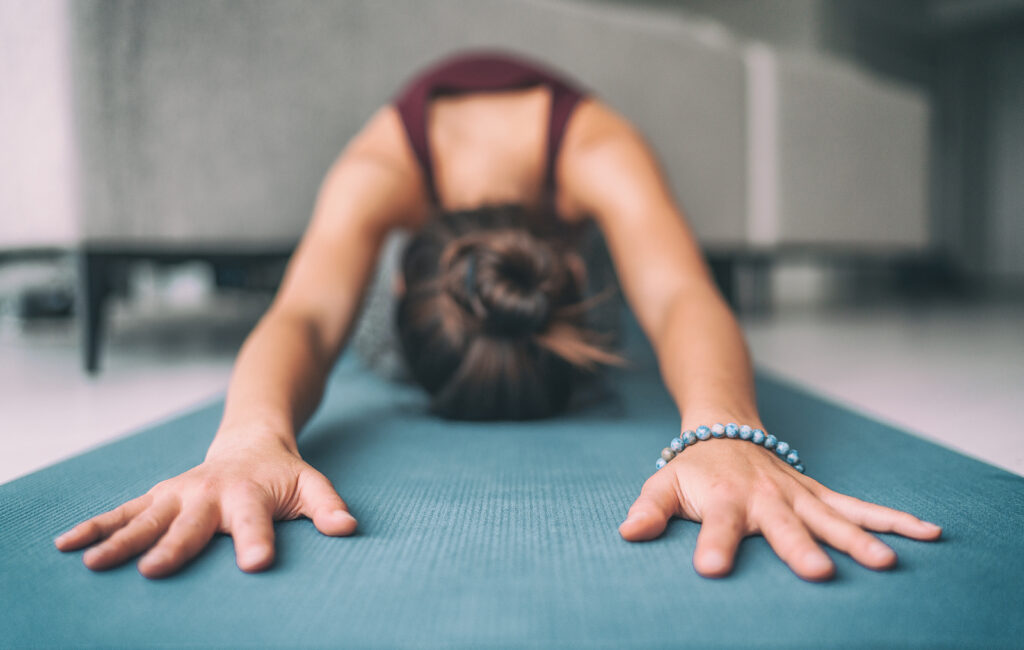 A close up of a woman reaching out on a yoga matt in a yoga pose. Learn how an equine sports therapist in Richmond, VA can assist you. Search for equine sports therapy in Richmond, VA or search for therapy with horses in Powhatan, VA today. 