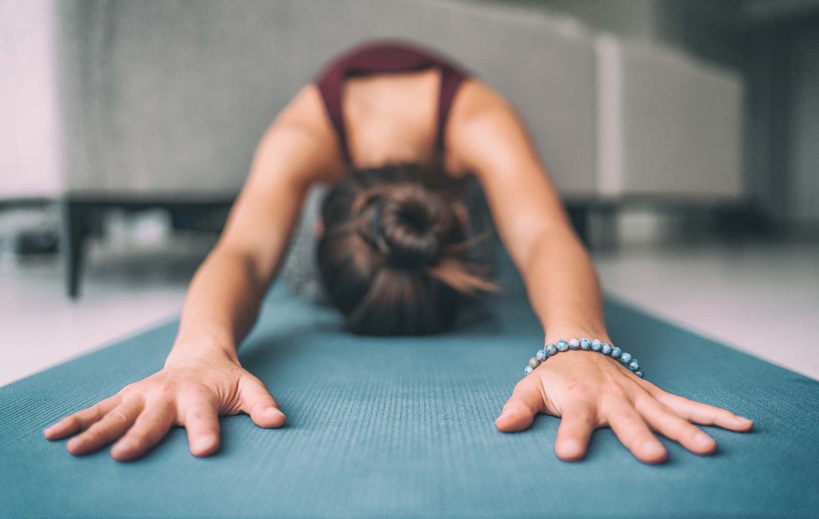 A woman stretches in child's pose on a yoga mat, arms extended forward in deep relaxation. How can mindfulness enhance your riding and overall well-being? An equine therapist in Powhatan, VA can help you find out.