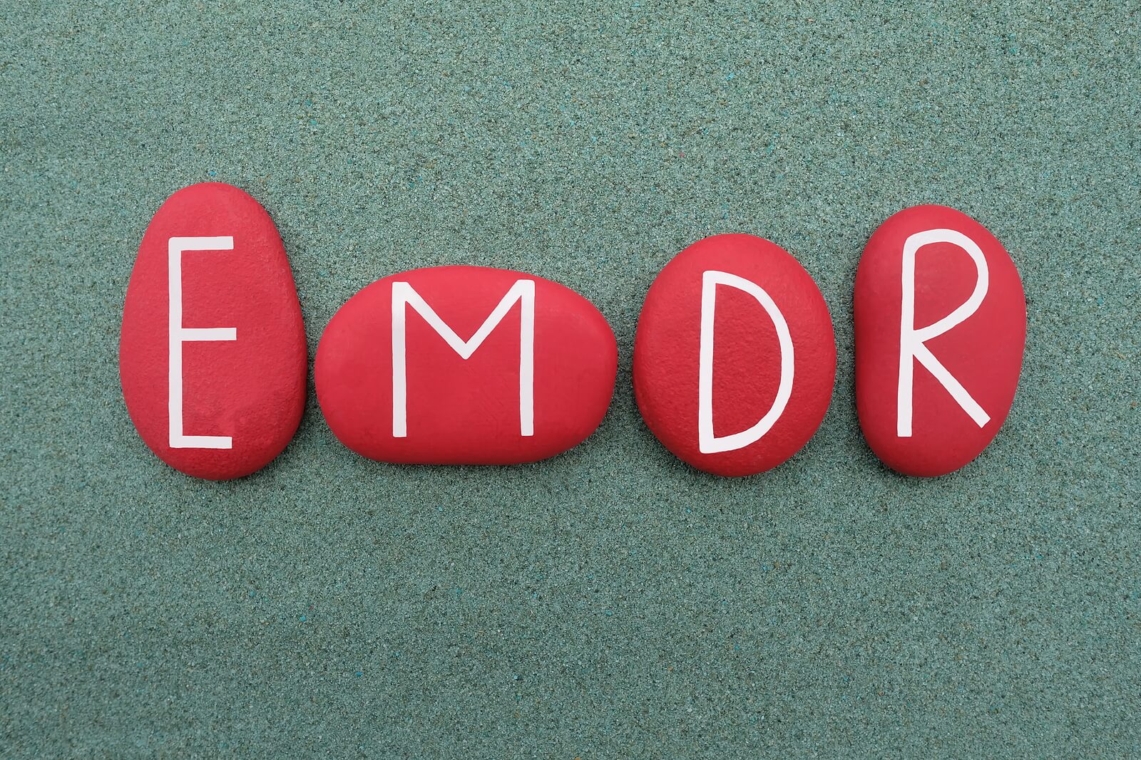 A close up of rocks that have letters that spell "EMDR". Learn how EMDR therapy in Richmond, VA can offer support in addressing trauma. Learn more about therapy for trauma in Richmond VA and how an EMDR therapist in Powhatan, VA can support you today.