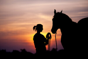 A silhouette of a horse rider standing in front of their horse. Learn more about how online therapy in Powhatan, VA can offer support with cultivating self esteem. Search for an equine therapist in Virginia for more support through anxiety therapy in Powhatan, VA today. 