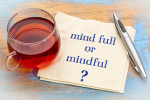 A close up of a napkin with the words “mindful or mind full” next to a cup of tea. Learn how mindfulness can help you overcome anxiety by contacting an anxiety therapist in Richmond, VA. Search for depression treatment in Richmond, VA or search for deprssion therapist in Powhatan, VA today. 