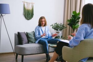 A young man engages in an open conversation during a therapy session, representing the healing power of working with a therapist for men in Powhatan, VA, receiving depression treatment in Fredericksburg, VA, or connecting with a dedicated depression therapist in Powhatan, VA. 