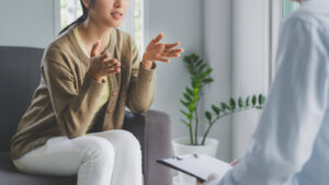 A woman gestures with her hands while sharing her story during a session of trauma therapy in Richmond, VA with a compassionate trauma therapist in New Kent, VA and Fredericksburg, VA. 