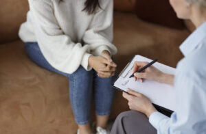A client speaks with a professional writing notes on a clipboard. This scene reflects the work of an EMDR therapist in Richmond, VA and the importance of trust in trauma therapy in Richmond, VA. Many clients also find support with an EMDR therapist in Powhatan, VA for their healing journey. 