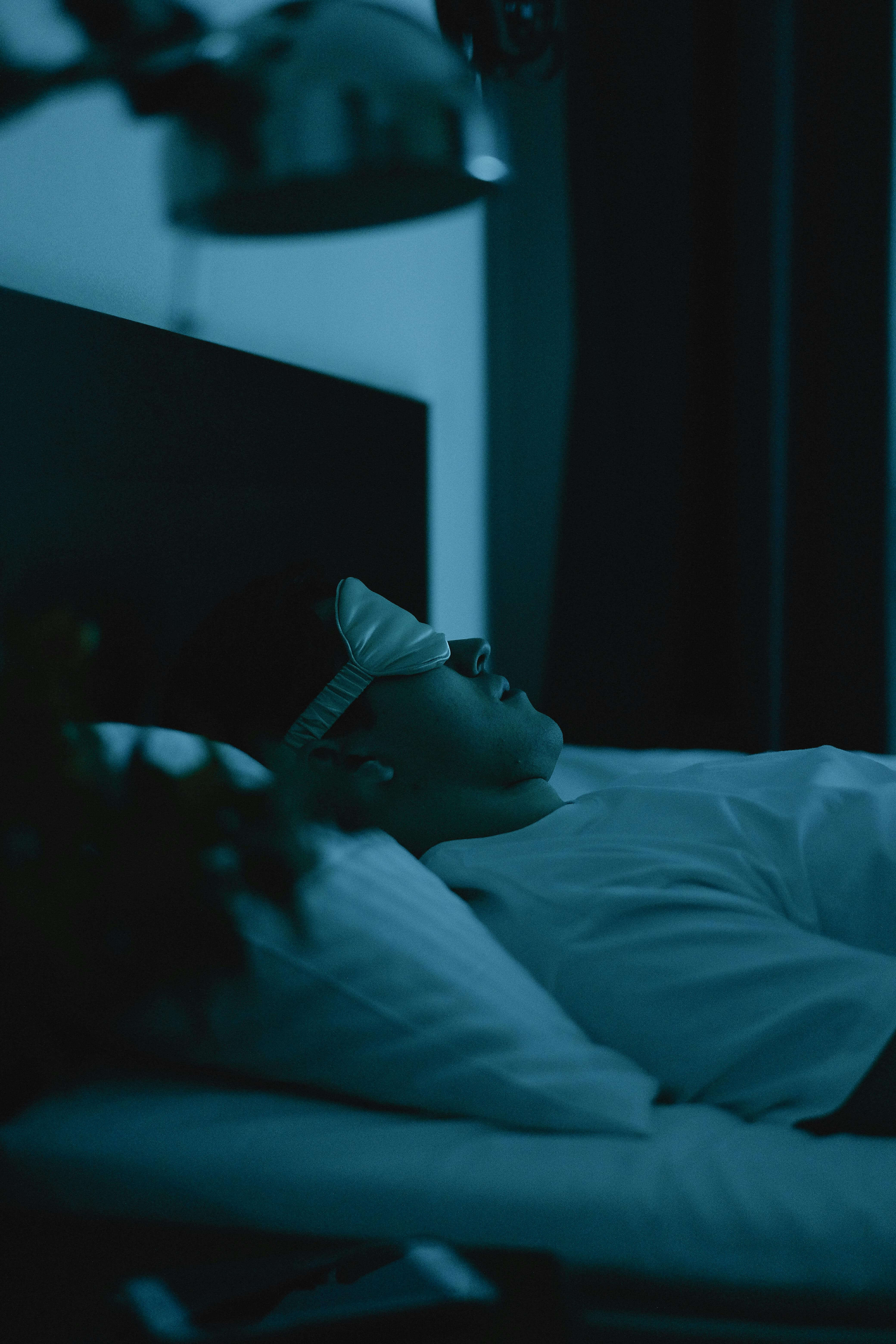 A person rests in a dark bedroom with a sleep mask, prioritizing restorative sleep to support immunity while coping with depression. Guidance from an online depression therapist in goochland, va, depression treatment in richmond, va, or depression treatment in powhatan, va can improve sleep and mood. 