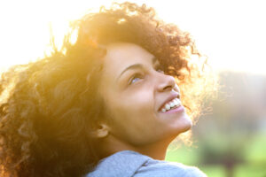 A woman smiles and looks upward with hope after completing EMDR intensives in Richmond VA, representing the healing possible through intensive therapy in Richmond, VA 