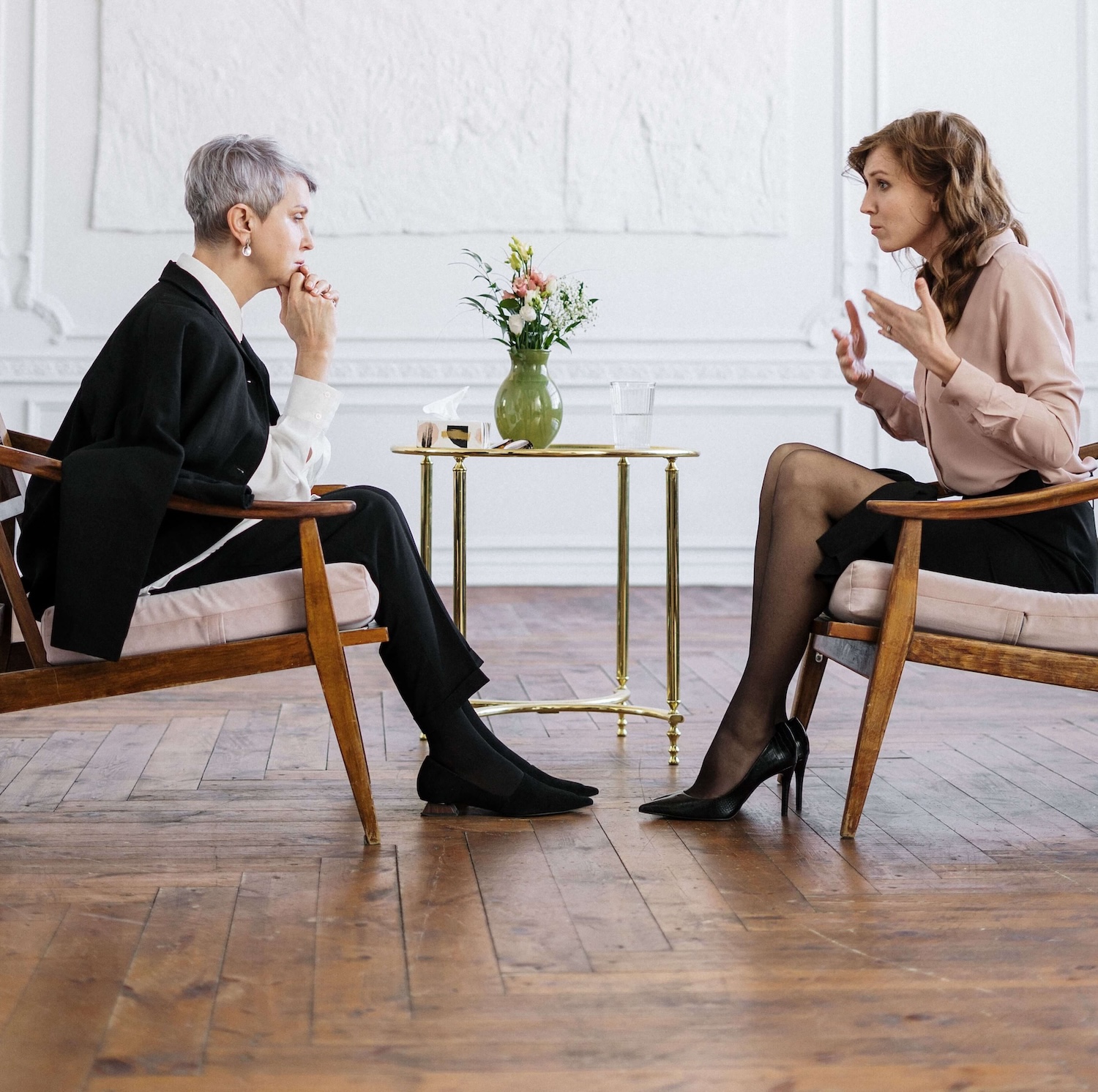 Two women sit facing each other in a bright, elegant room, one listening intently as the other speaks and gestures. This kind of focused one-on-one work is the heart of an EMDR intensive in Richmond, VA. Intensive EMDR therapy in Richmond, VA gives clients extended time with an EMDR therapist in Richmond, VA to process a difficult memory fully.